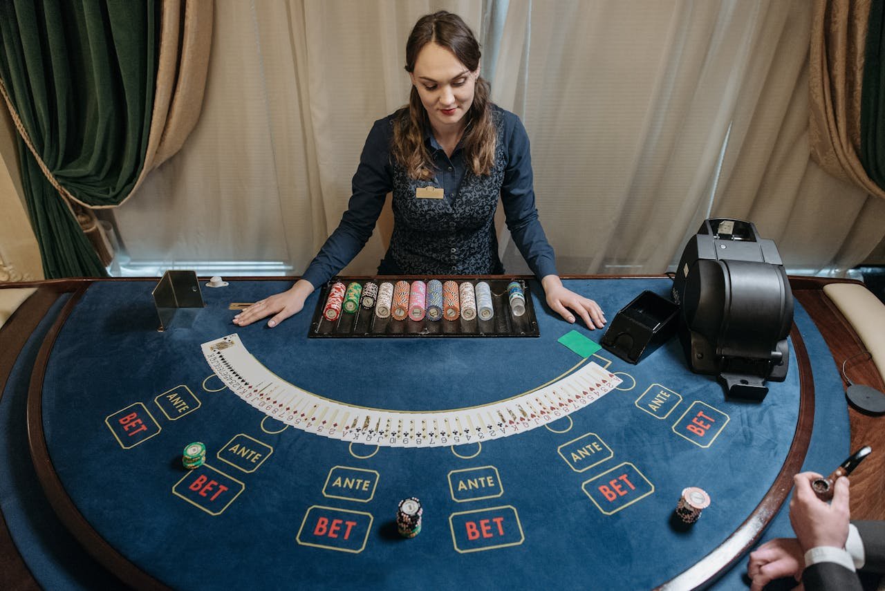 Professional female casino dealer managing a gaming table with chips and cards in a luxurious setting.