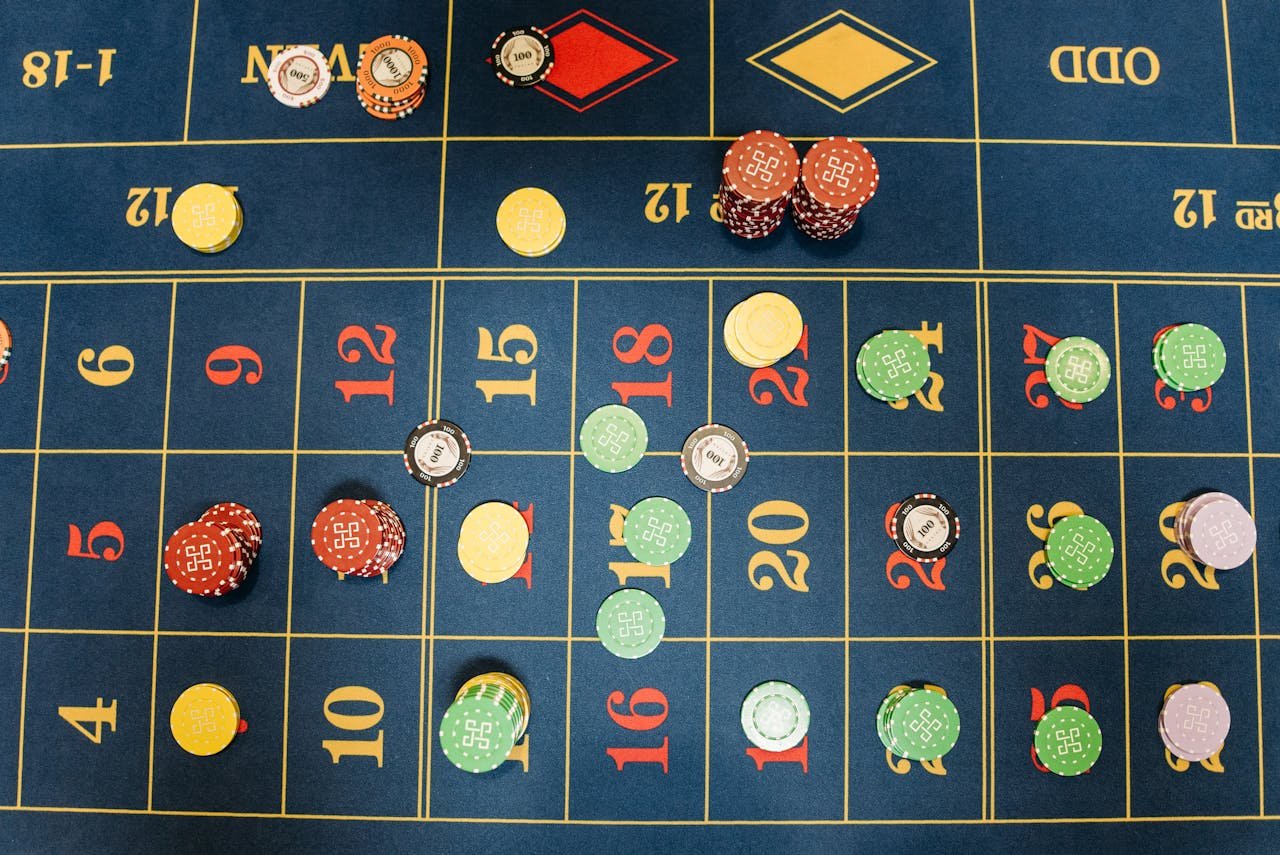 Aerial view of a roulette table with colorful poker chips showing a vibrant gambling scene.