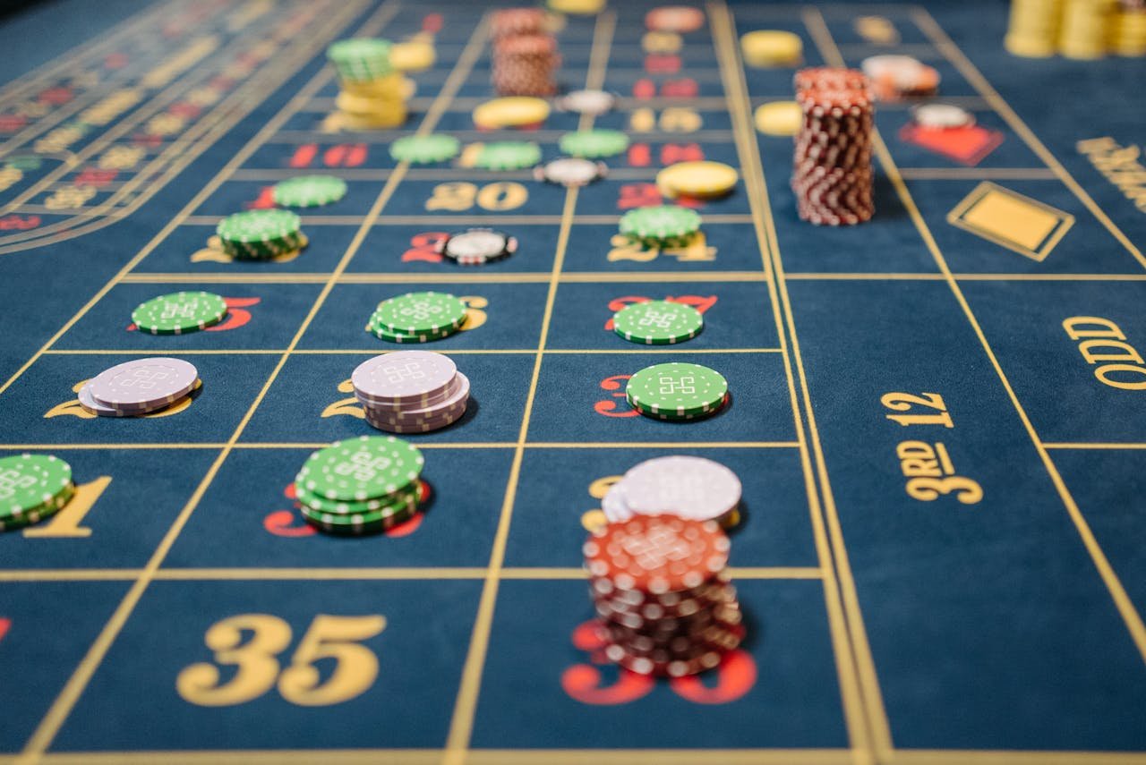 Close-up of a roulette table with colorful poker chips, capturing the thrill of casino gambling.